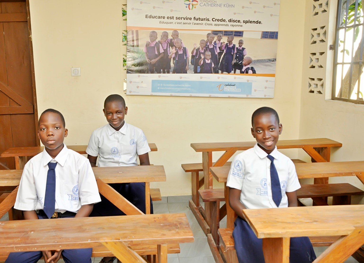 Three pupils in uniform seated in the classroom.