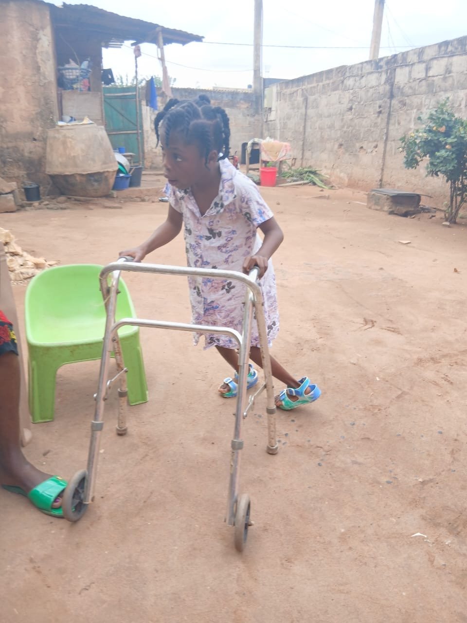 Gracia at home, standing with her walking frame.