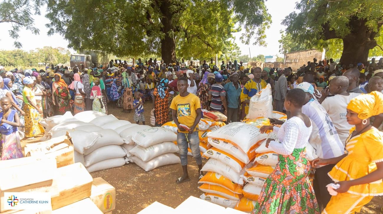 Families gathered around food supplies during the Catherine Kühn Foundation’s solidarity initiative.
