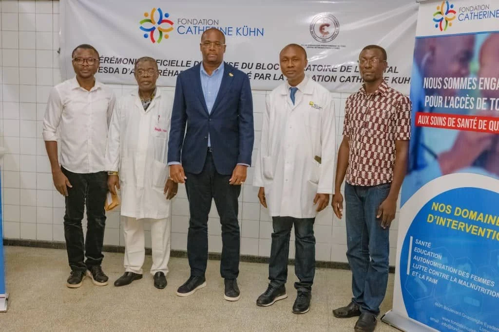 Healthcare professionals at a ceremony in front of a Foundation banner