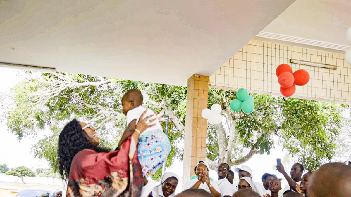 Manuella Santos lifts a child in a shared moment of joy
